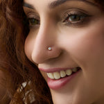 Diamond nose pin design from Kerala in gold worn on the nose in a close-up portrait, showcasing a timeless and elegant traditional jewelry look
