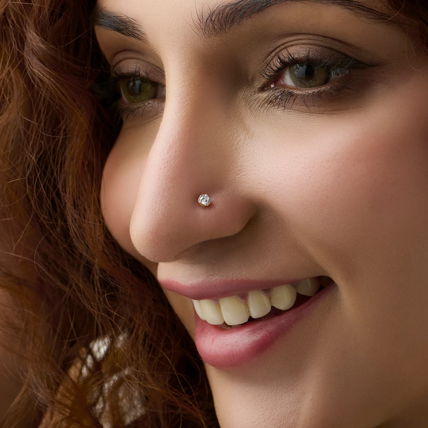 Diamond nose pin design from Kerala in gold worn on the nose in a close-up portrait, showcasing a timeless and elegant traditional jewelry look
