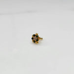Close-up of a full-bloom green stone nose pin with gold heart accents