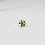 A gold nose pin shaped like a star, set entirely with smoky grey crystal stones