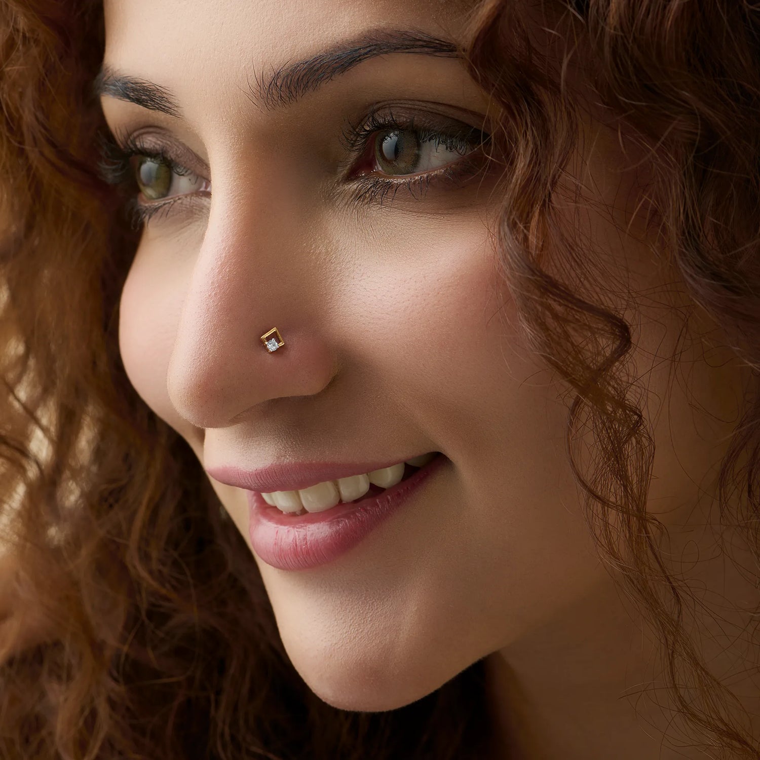 Woman wearing elegant gold nose pin close-up portrait