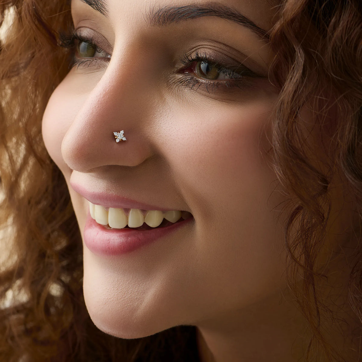 Woman wearing elegant flower gold nose pin close-up portrait