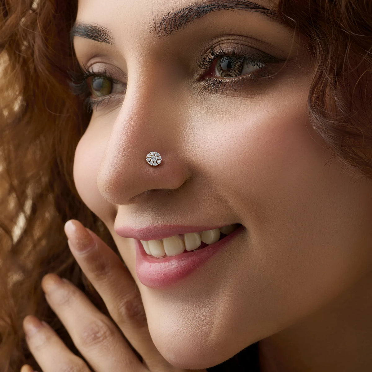 Woman wearing elegant diamond nose pin design from kerala in gold with sparkling finish