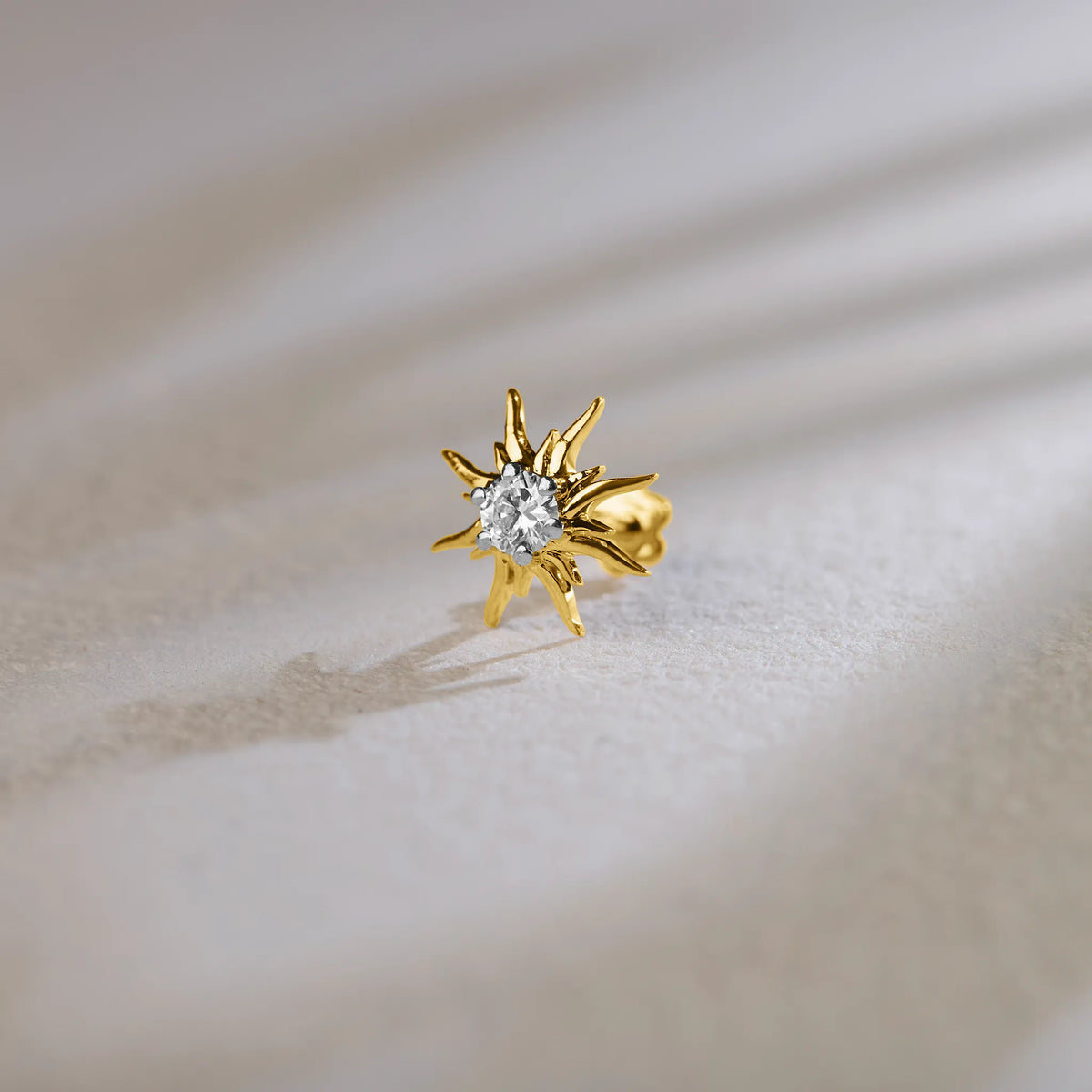 Sunburst-shaped diamond stud earring in 14k gold