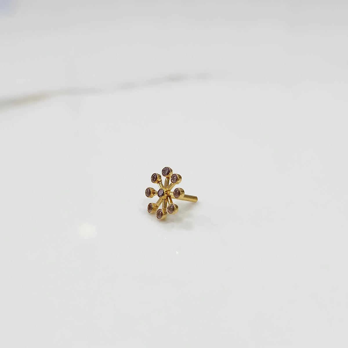 Sunburst diamond nose pin with gold spoke setting, jewelry photography