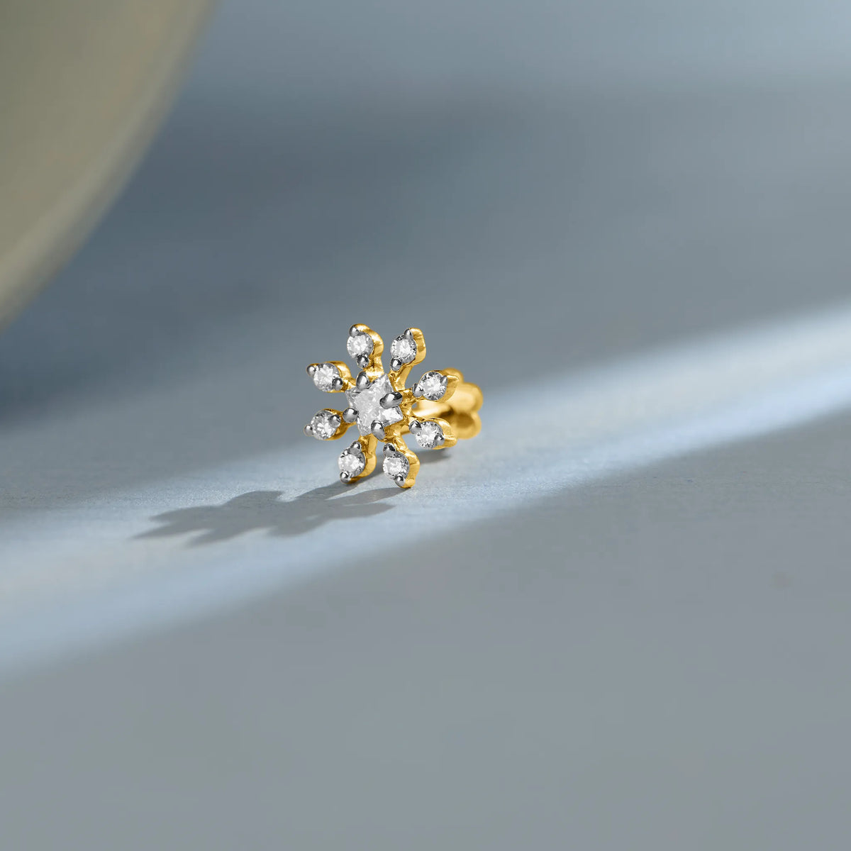 14k gold stud earring featuring diamonds arranged in a swirling pinwheel pattern