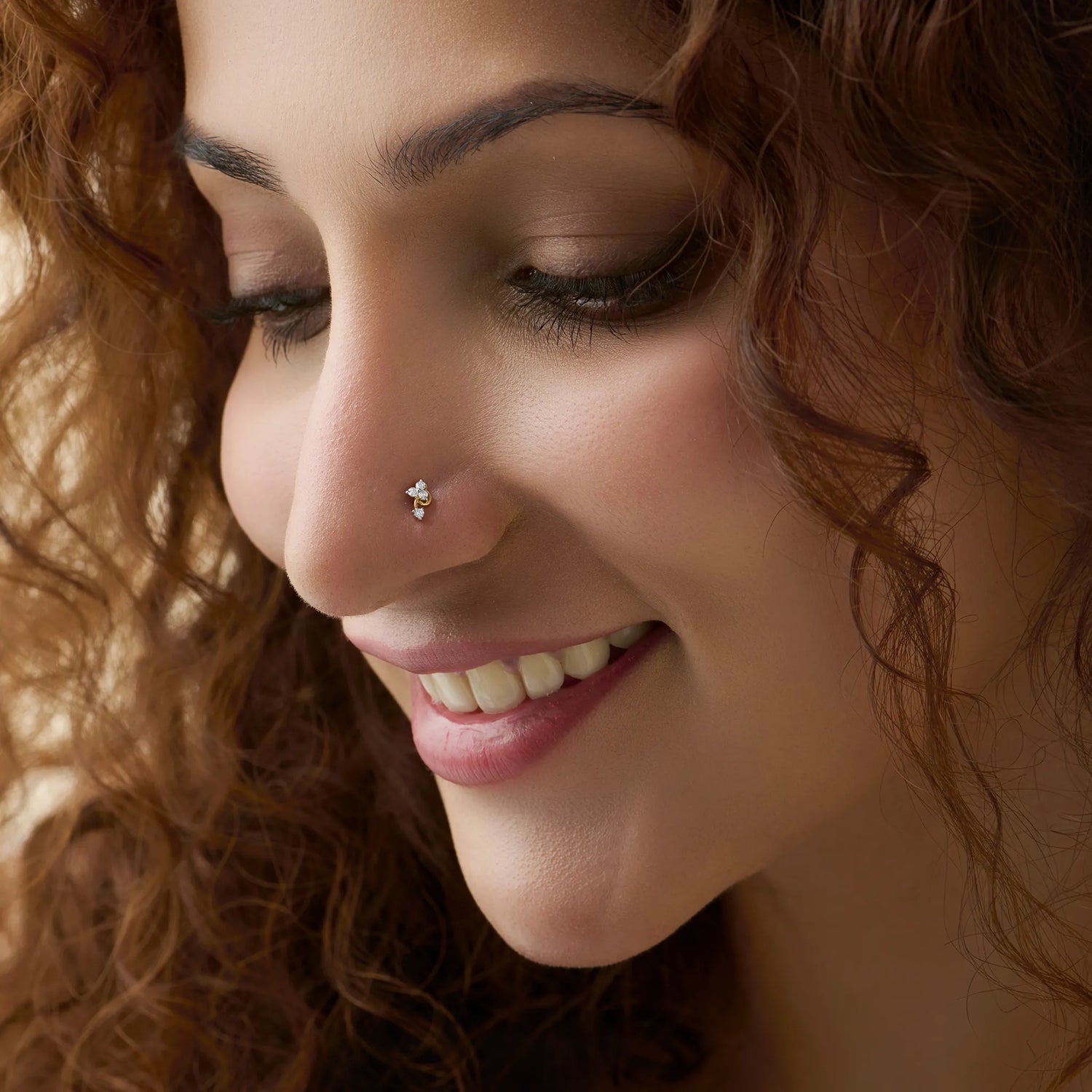 Model showcasing a delicate three-diamond cluster nose pin