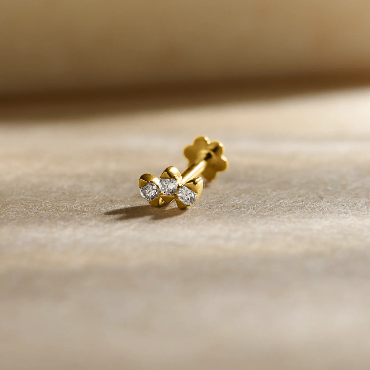 Trending nose pin gold with elegant twin stone design featuring sparkling solitaire stones set in a polished gold base on a soft neutral background