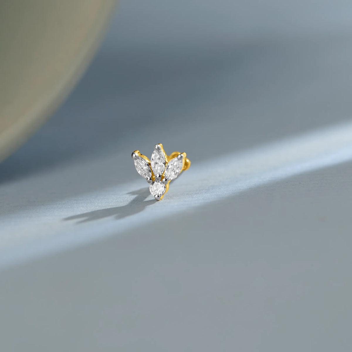 New nose pin design gold with elegant butterfly-inspired twin stone pattern set in a polished gold base on a soft pastel background