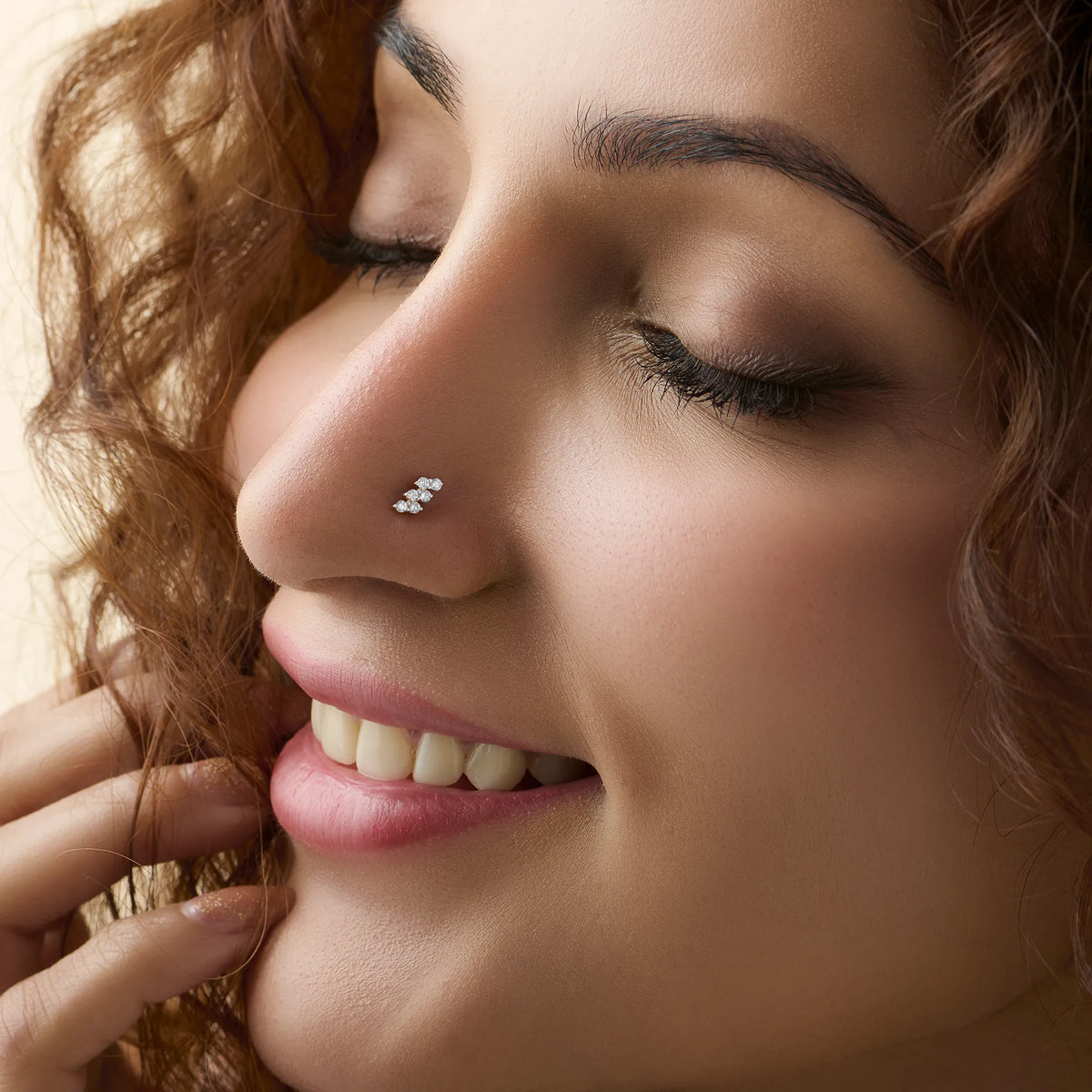 Smiling woman wearing stylish gold nose pin side profile portrait