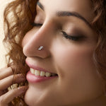 Smiling woman wearing stylish gold nose pin side profile portrait