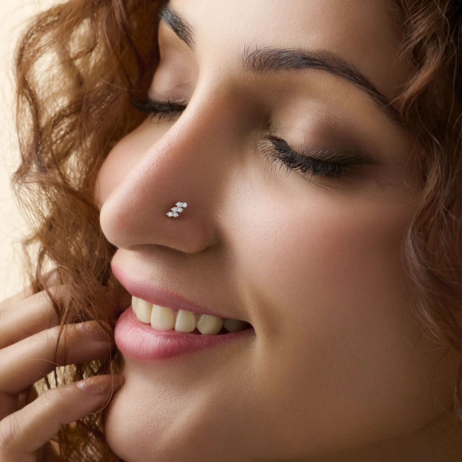 Smiling woman wearing stylish gold nose pin side profile portrait