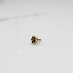 Traditional gold nose pin featuring a round black gemstone flower design