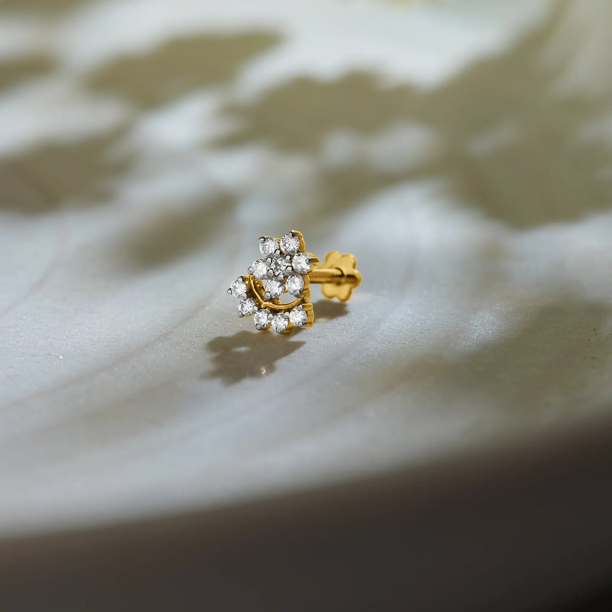 Floral cluster lab grown gold nose pin with sparkling diamonds on soft background