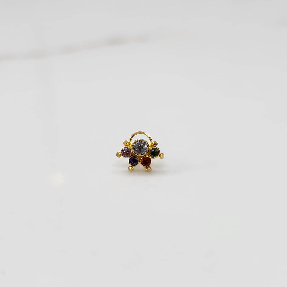 Gold ring with multicolor stone cluster in purple and clear tones