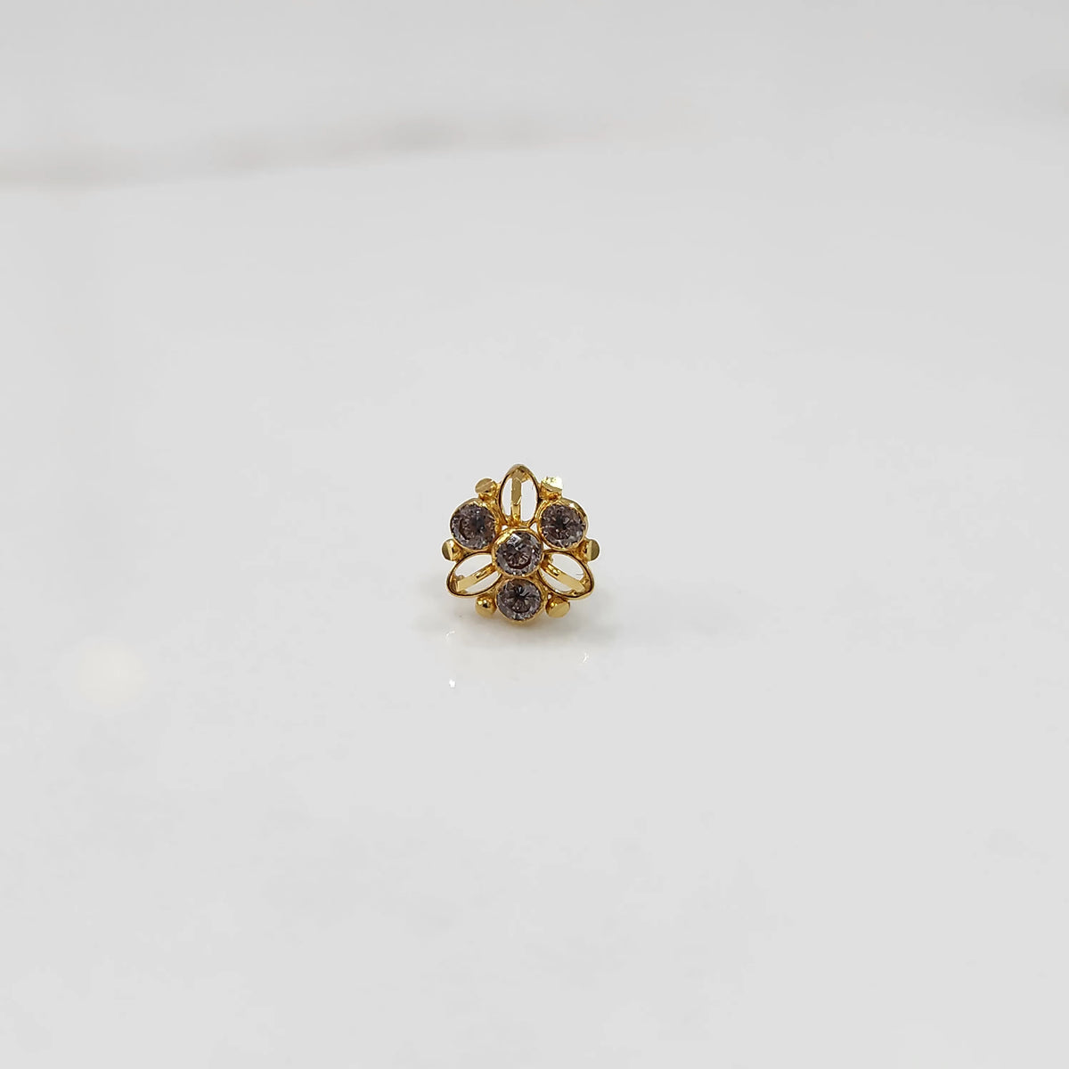 Top view of gold filigree ring with purple oval gemstones