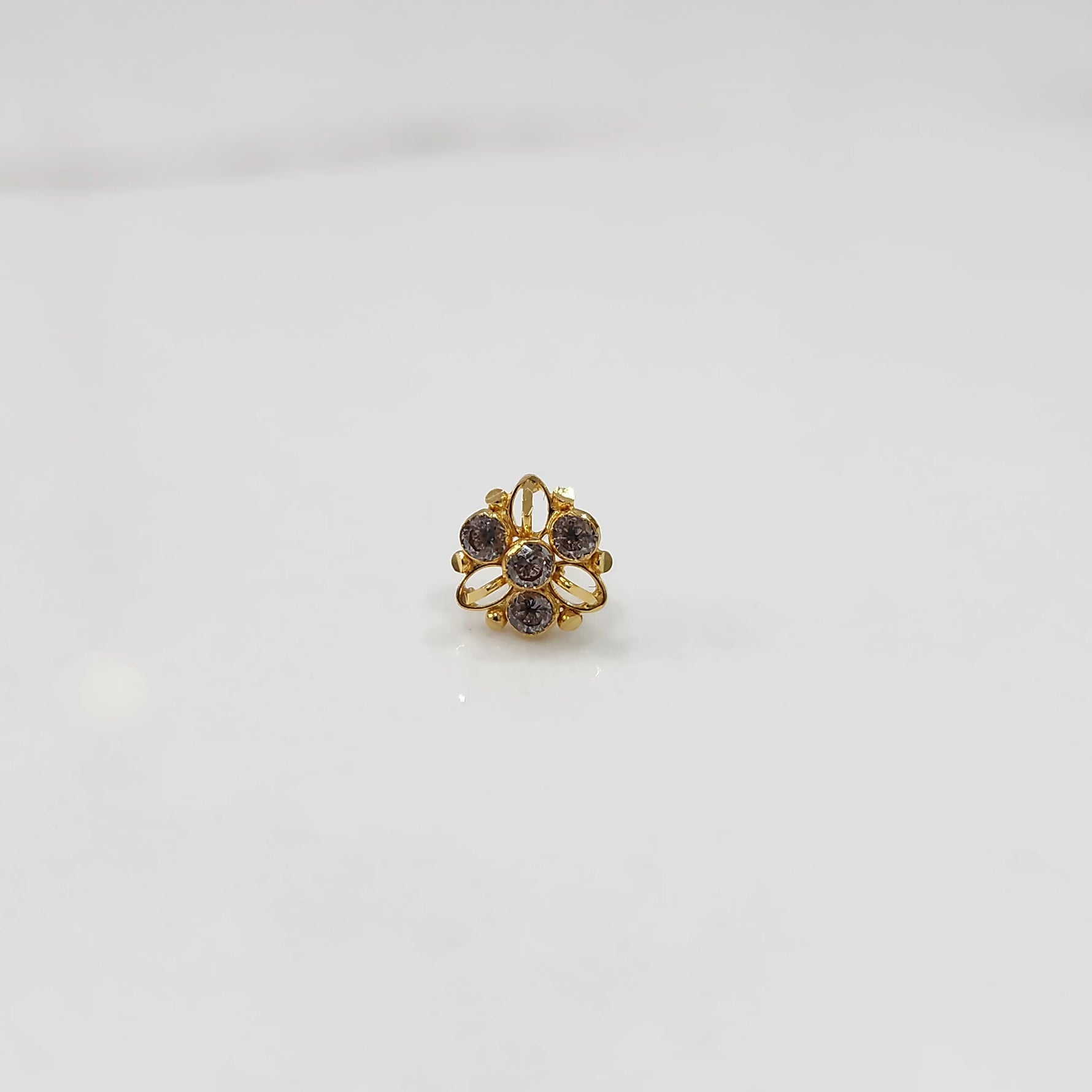 Top view of gold filigree ring with purple oval gemstones