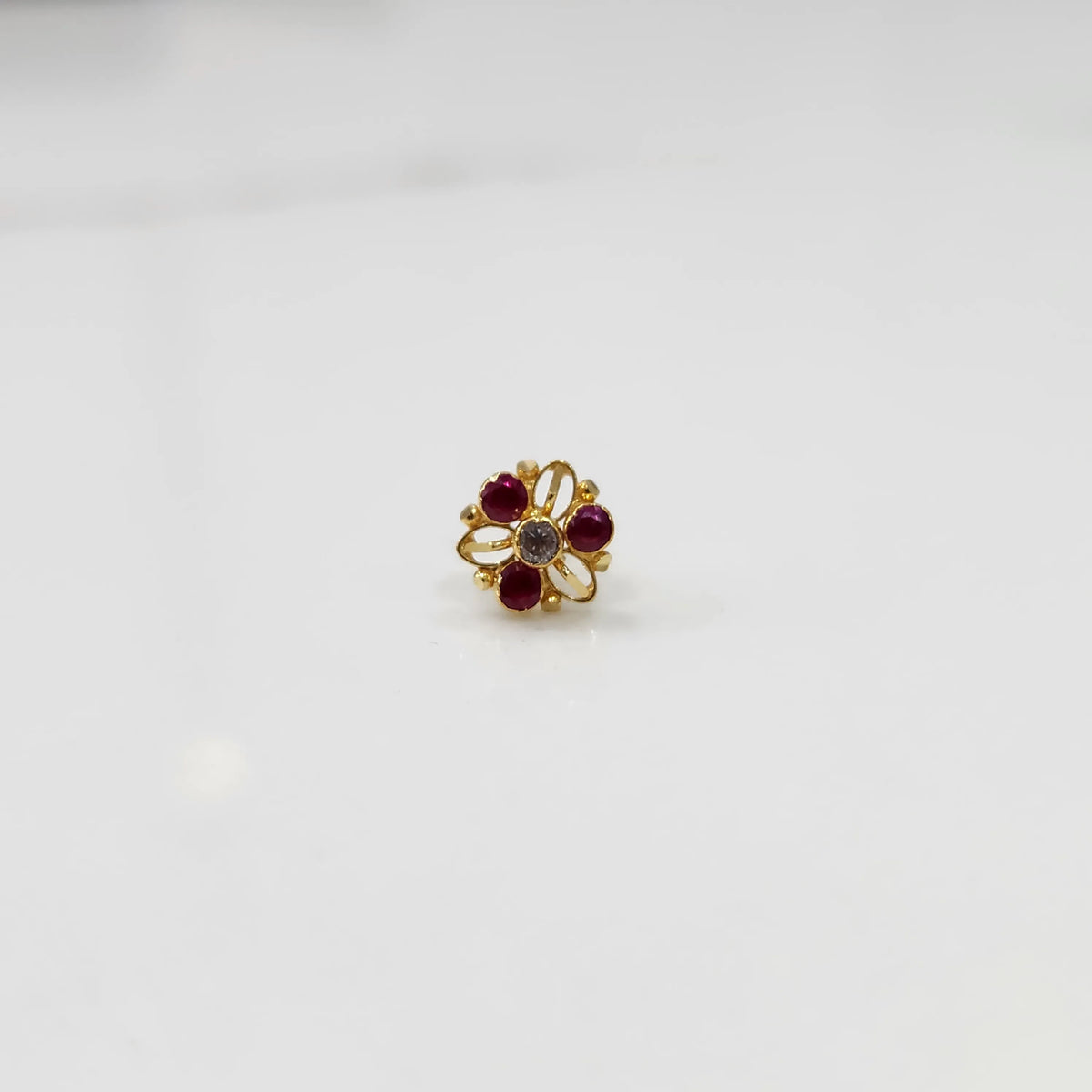 Top view of gold filigree ring with ruby-red oval gemstones