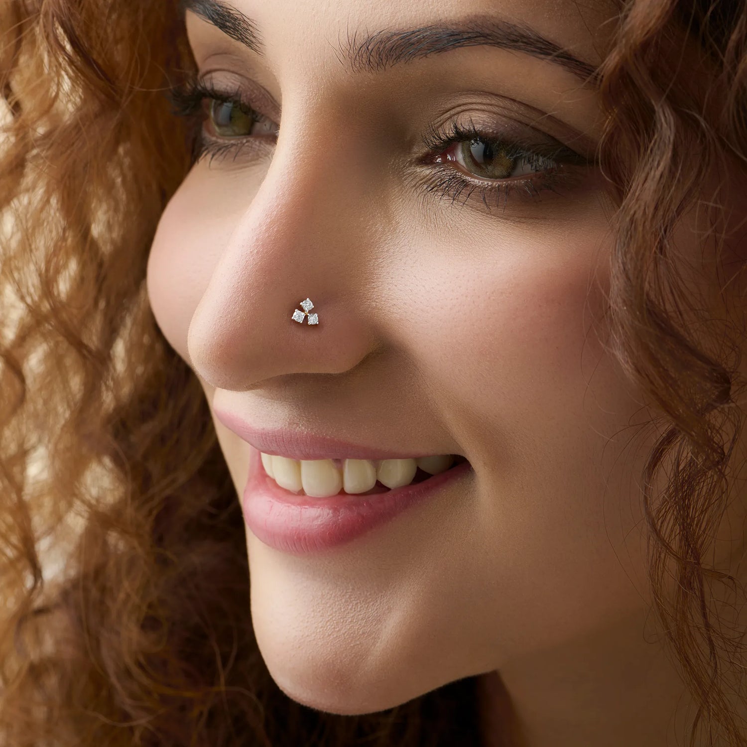 Woman wearing stylish gold nose pin side profile portrait