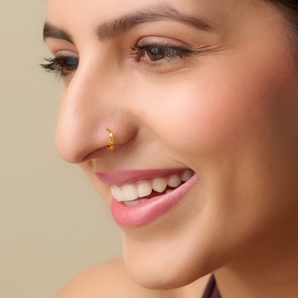 Close-up of textured gold nose ring design
