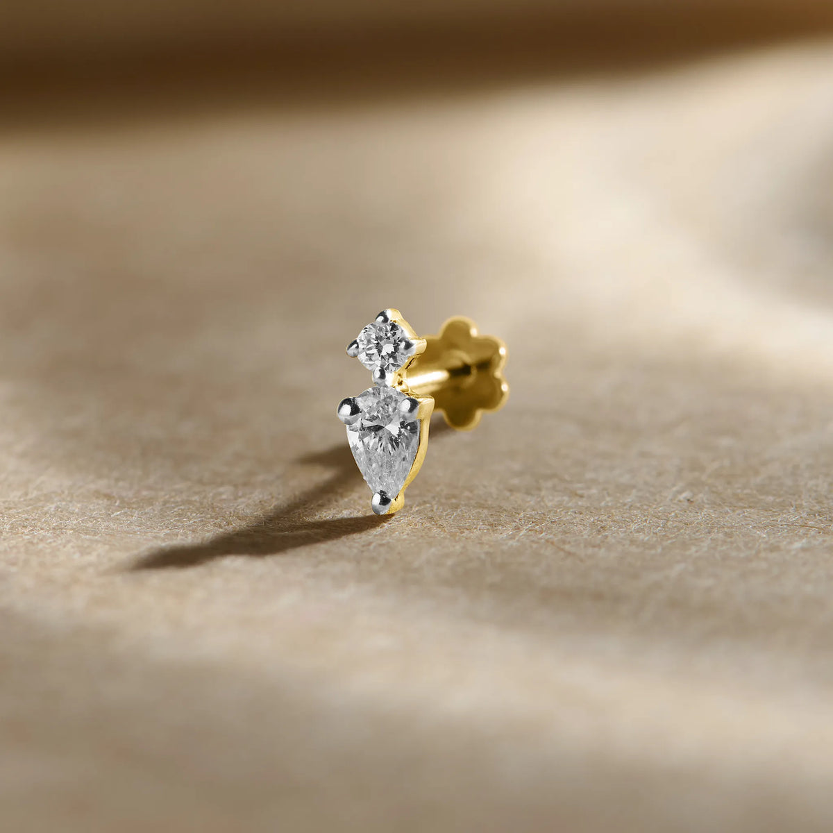 New nose pin design gold with elegant dual-stone leaf-inspired pattern set in a polished gold base on a soft neutral background