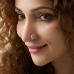 Vertical diamond nose stud worn by a smiling woman, close-up beauty shot