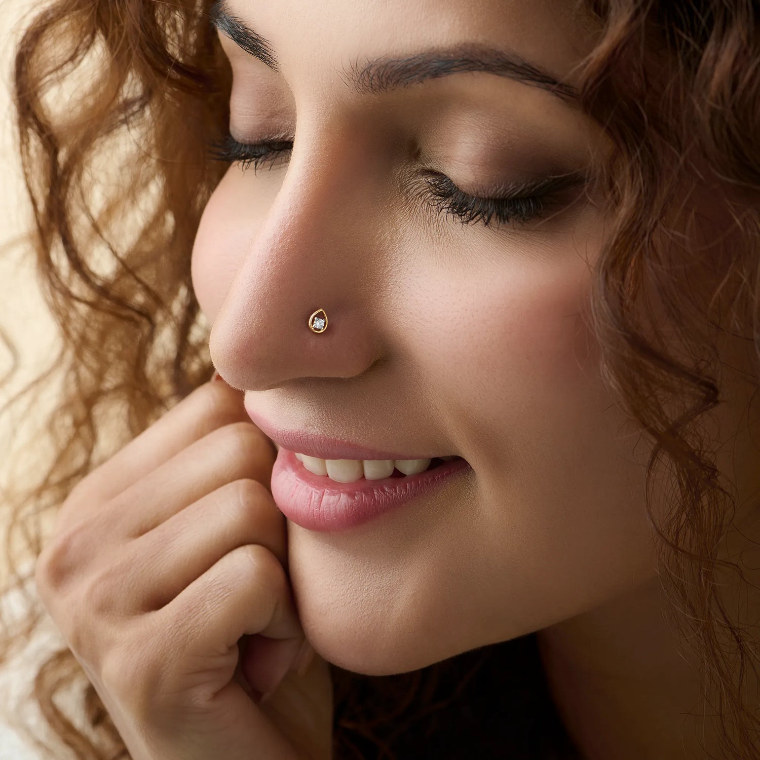 Gold nose pin design worn on the nose in a close-up portrait, showcasing a graceful and minimal everyday jewelry look