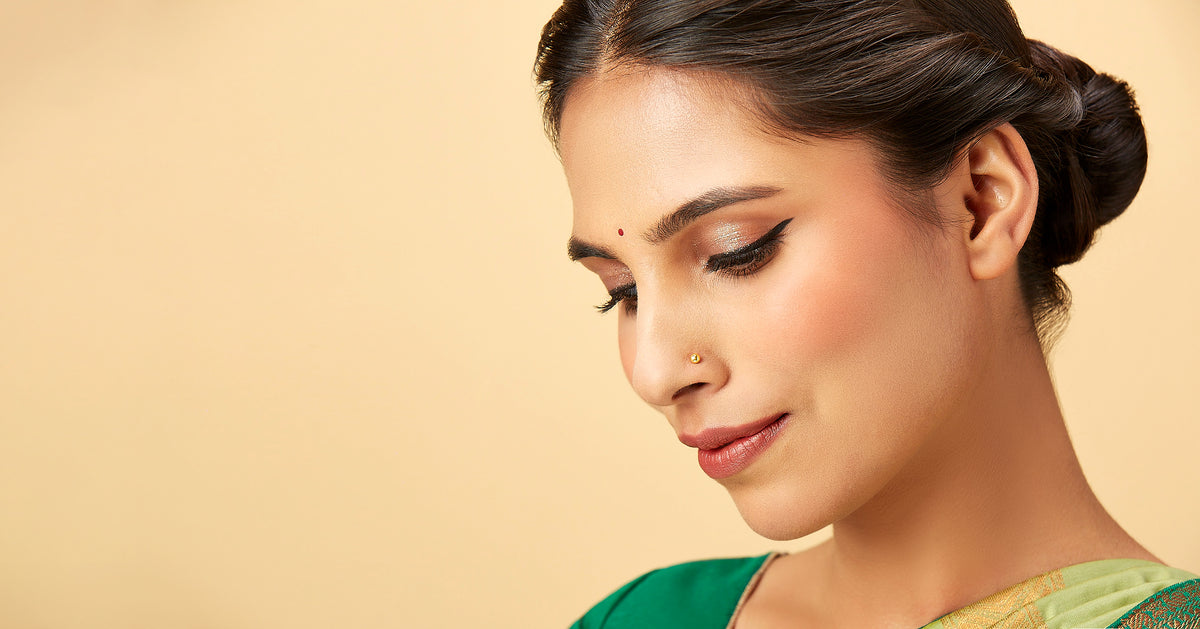  Woman with bindi and gold nose pin wearing green saree