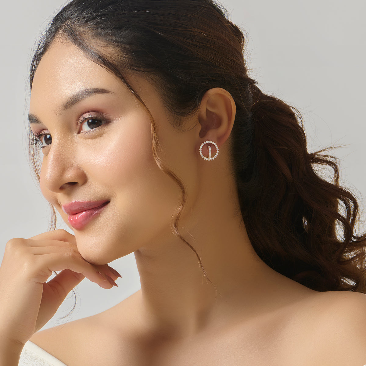 Woman with round diamond stud earring on ear