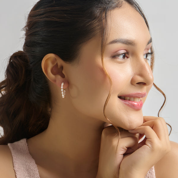 Close-up of woman wearing gold diamond hoop earring