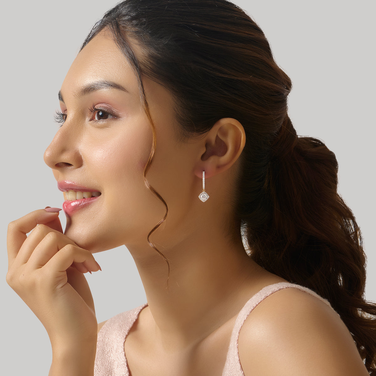 Side profile of woman wearing gold drop earring