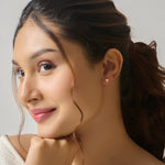 Close-up of woman wearing gold heart stud earring