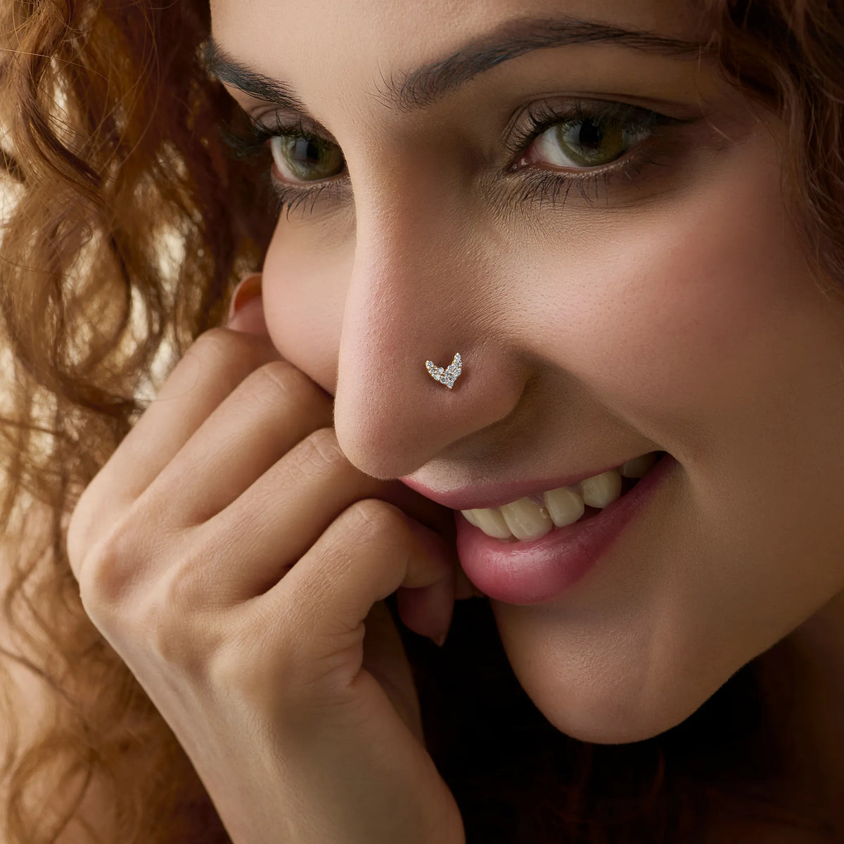 Woman wearing elegant gold V-shaped nose pin close-up portrait