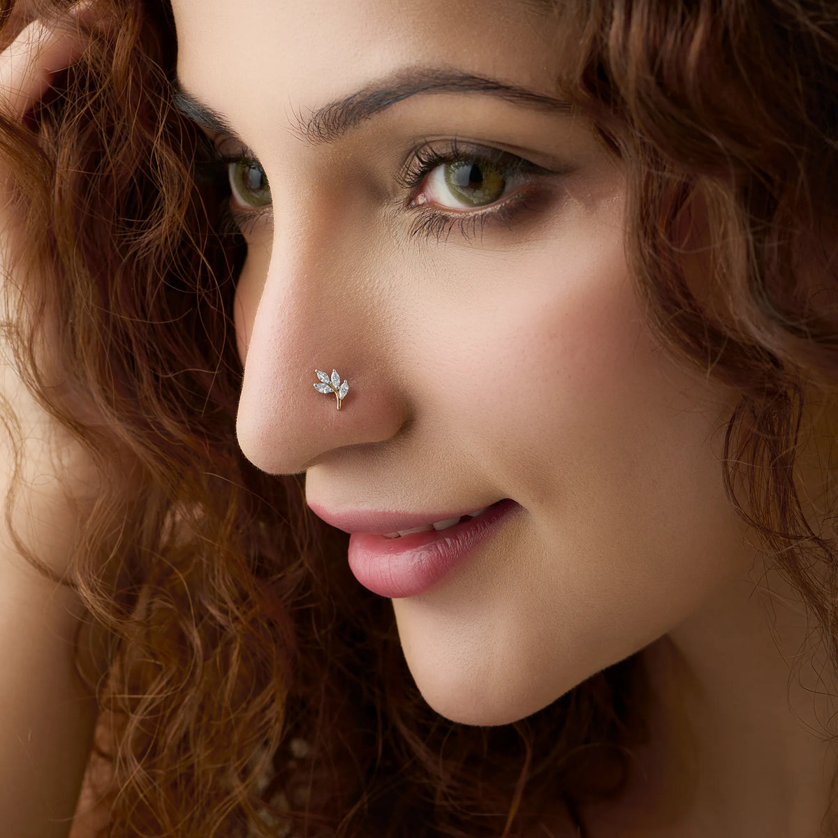 Close-up of woman wearing a nose stud with a three-leaf marquise diamond design