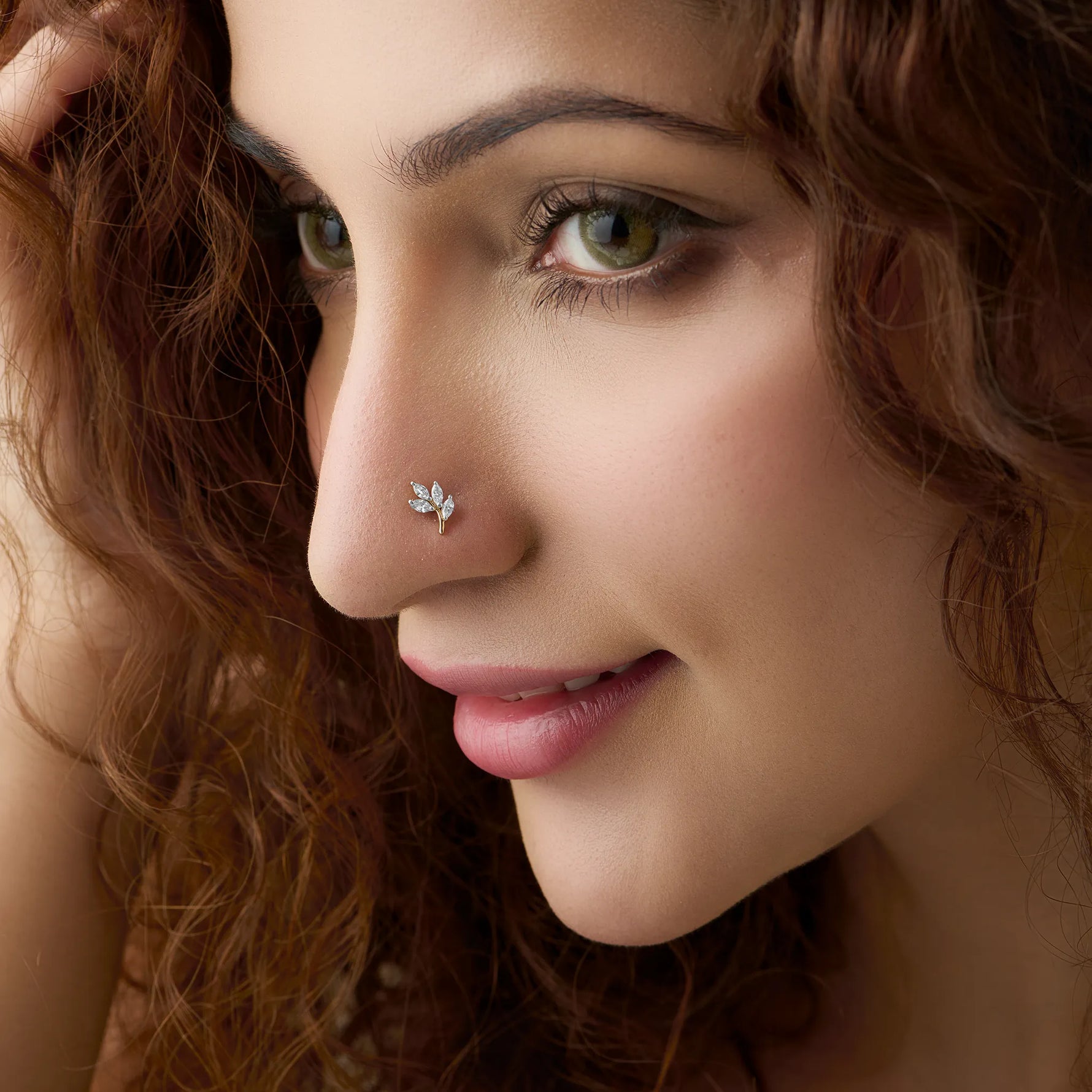 Close-up of woman wearing a nose stud with a three-leaf marquise diamond design
