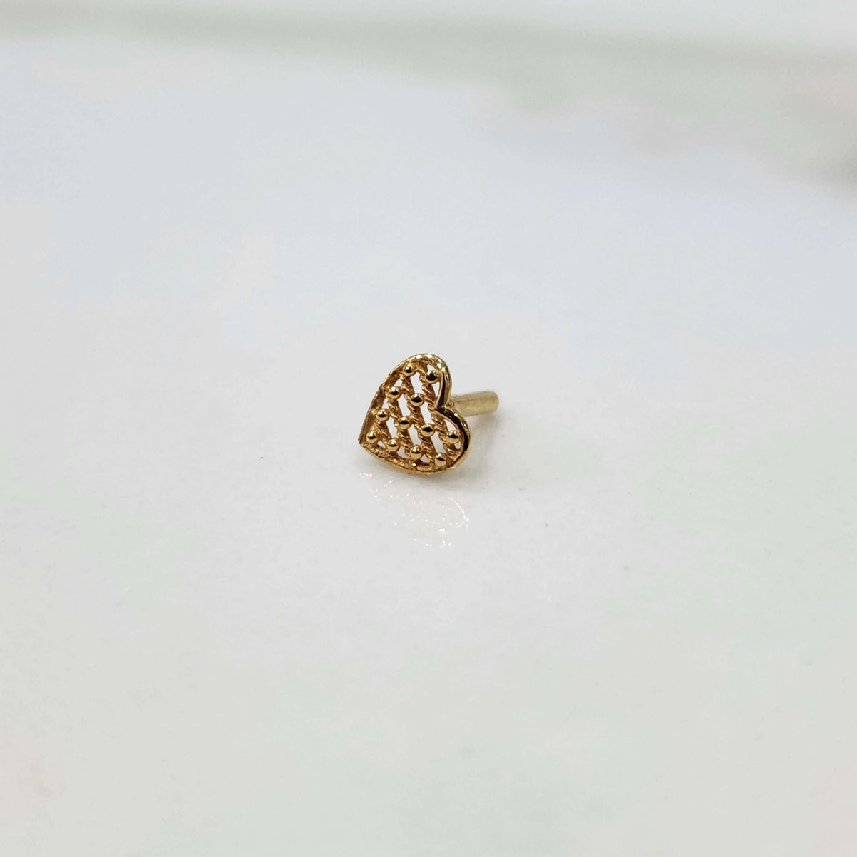Yuvora gold heart shaped nose pin on white background
